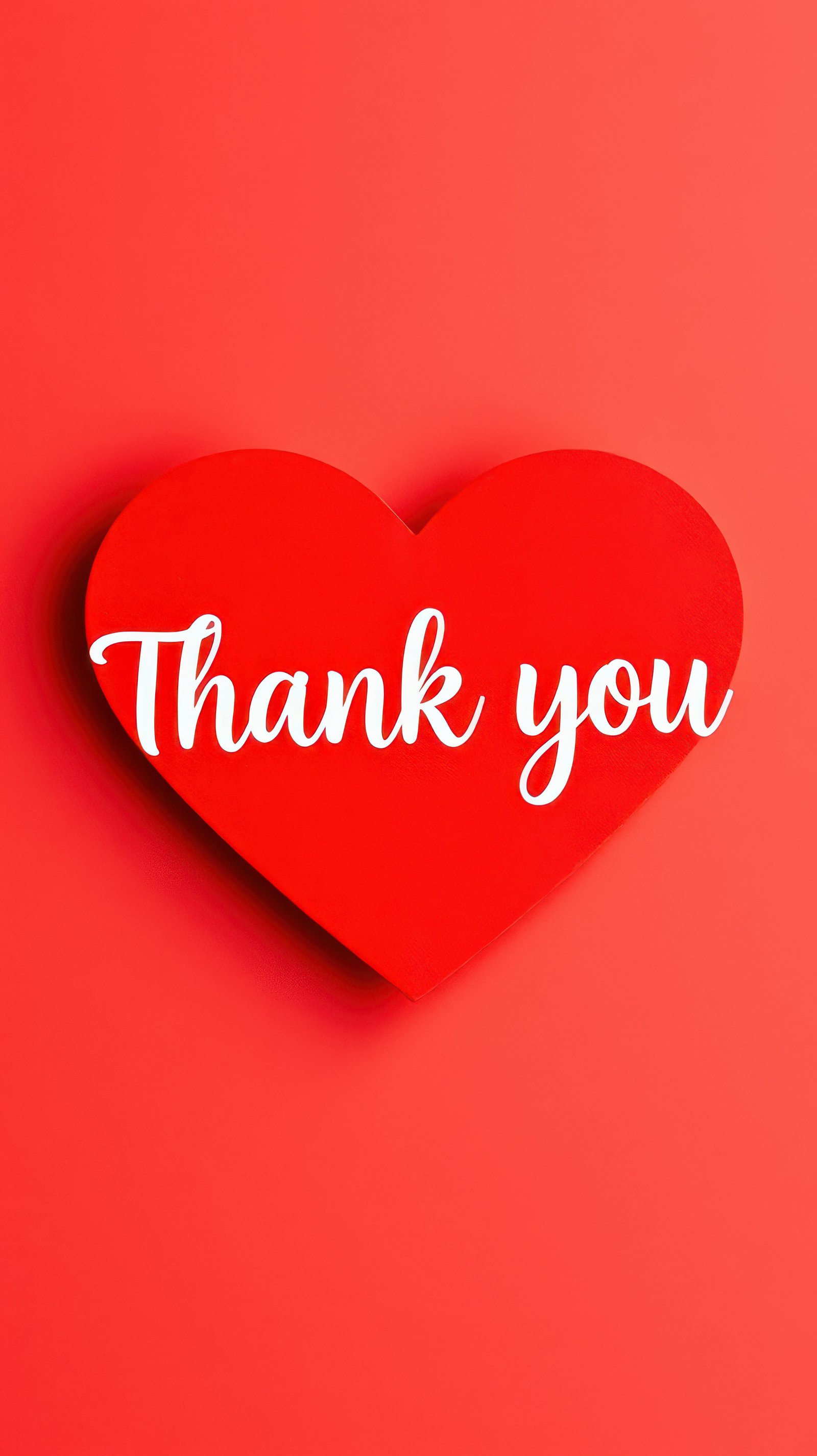 Heart-shaped card displays thank you message against a bold coral background for appreciation and gratitude moments
